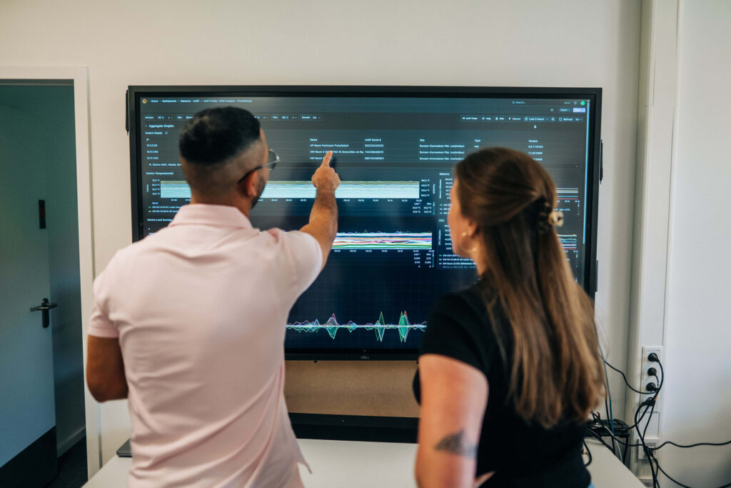 Kerim und Svenja vor einem Dashboard
