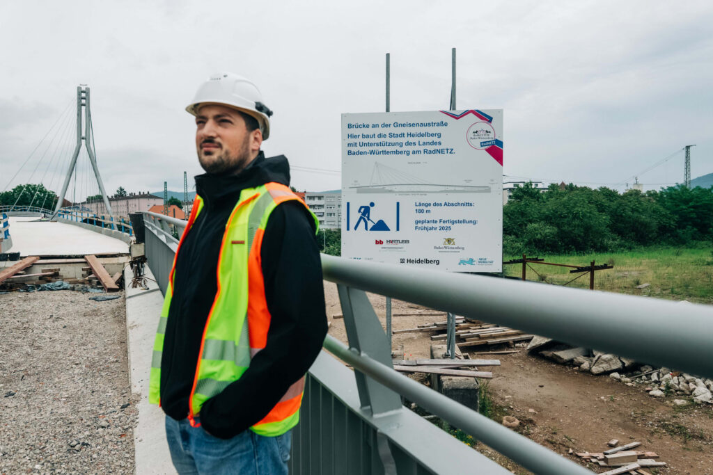 Bauingenieur steht angelehnt ans Brückengeländer