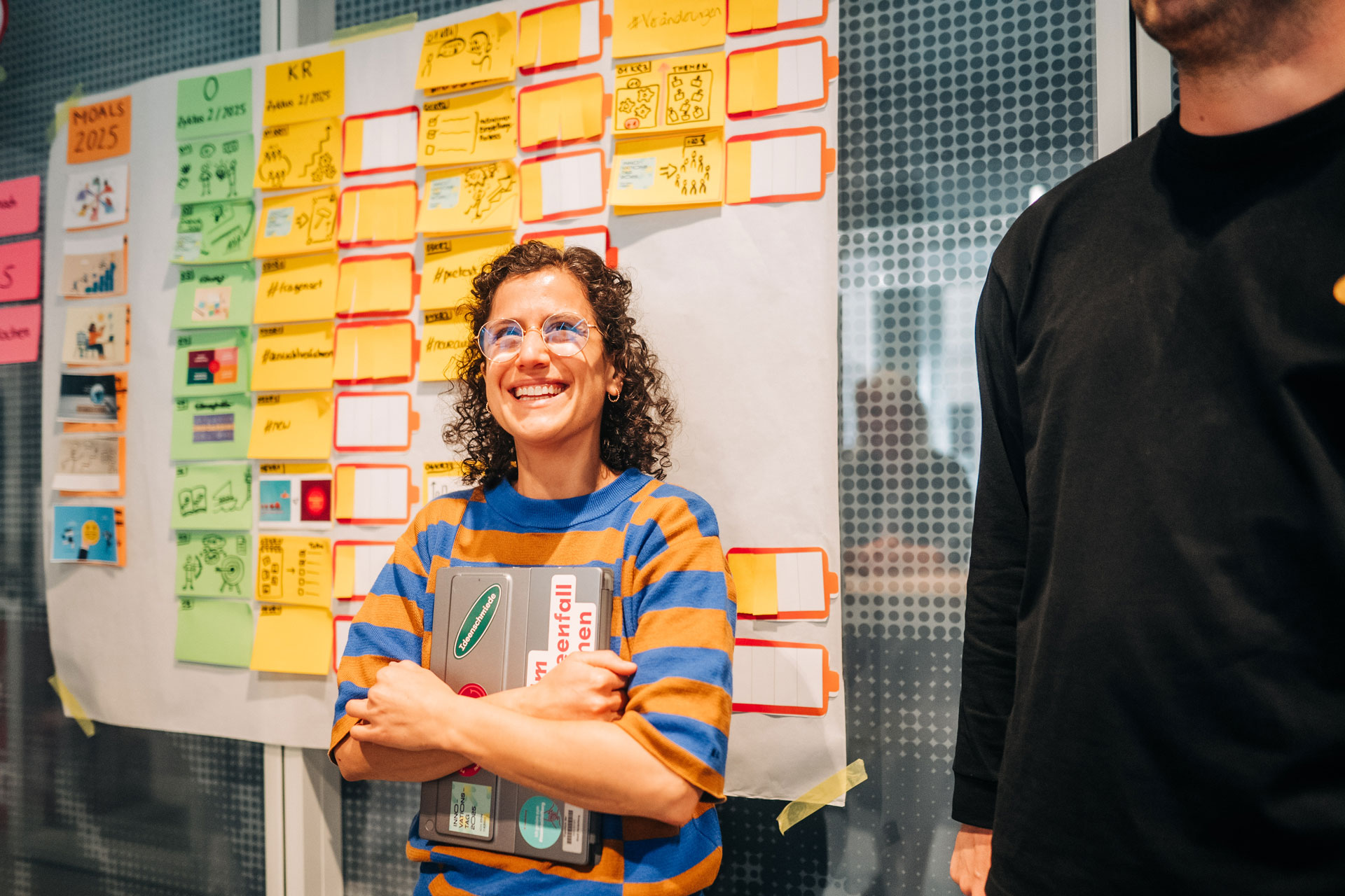 Eine Kollegin der Stadtverwaltung steht vor einem Projektplan