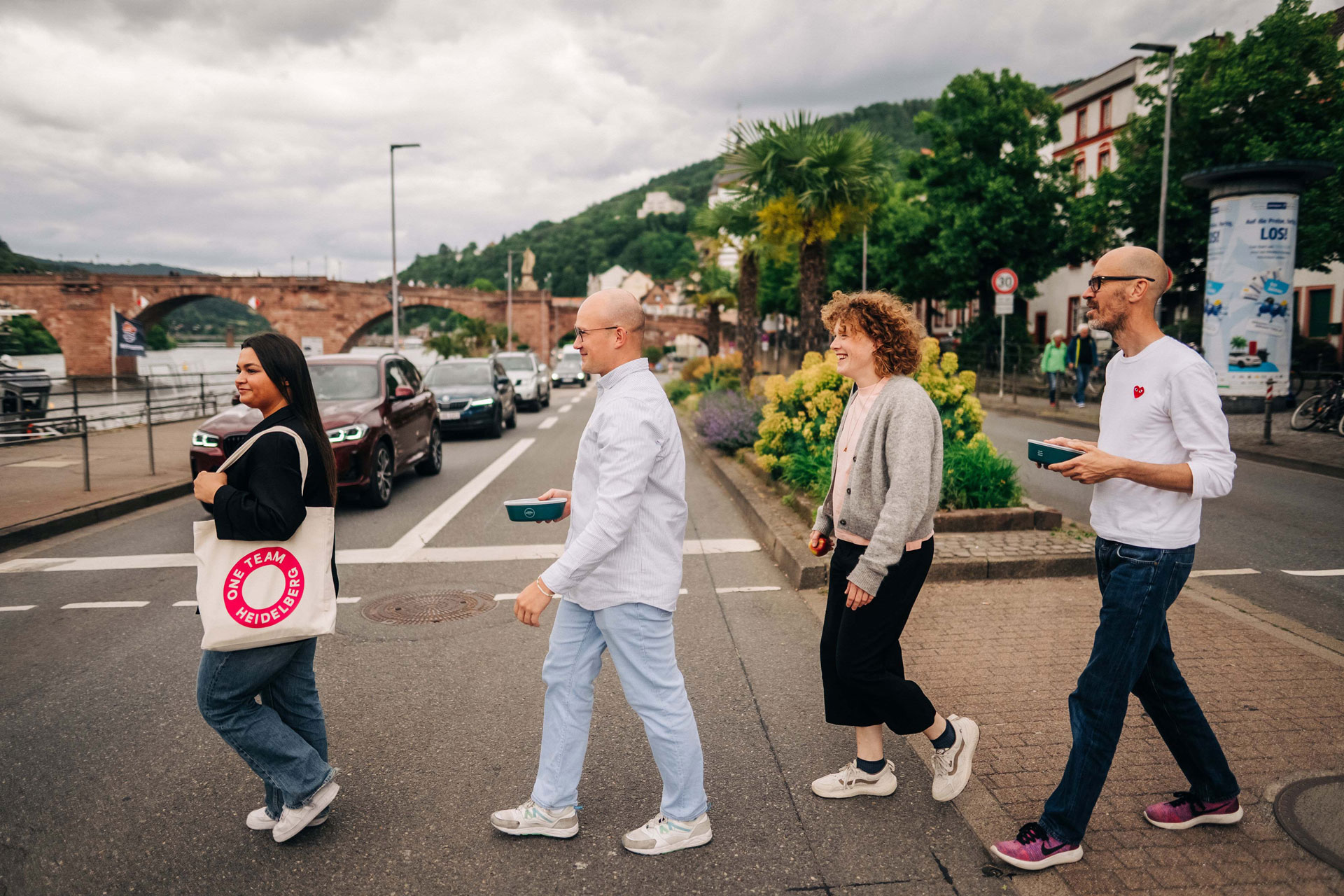 Vier Kollegen laufen in der Pause in Richtung Neckar