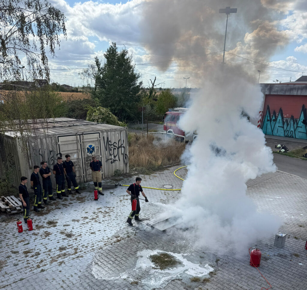 Auszubildende der Feuerwehr Heidelberg nehmen an einer Löschübung teil.